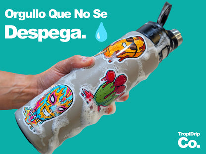 Decorative water bottle with colorful latino stickers held by a hand against a teal background, featuring the brand 'TropiDrip Co.' and teh motto 'Orgullo que no se despega'!